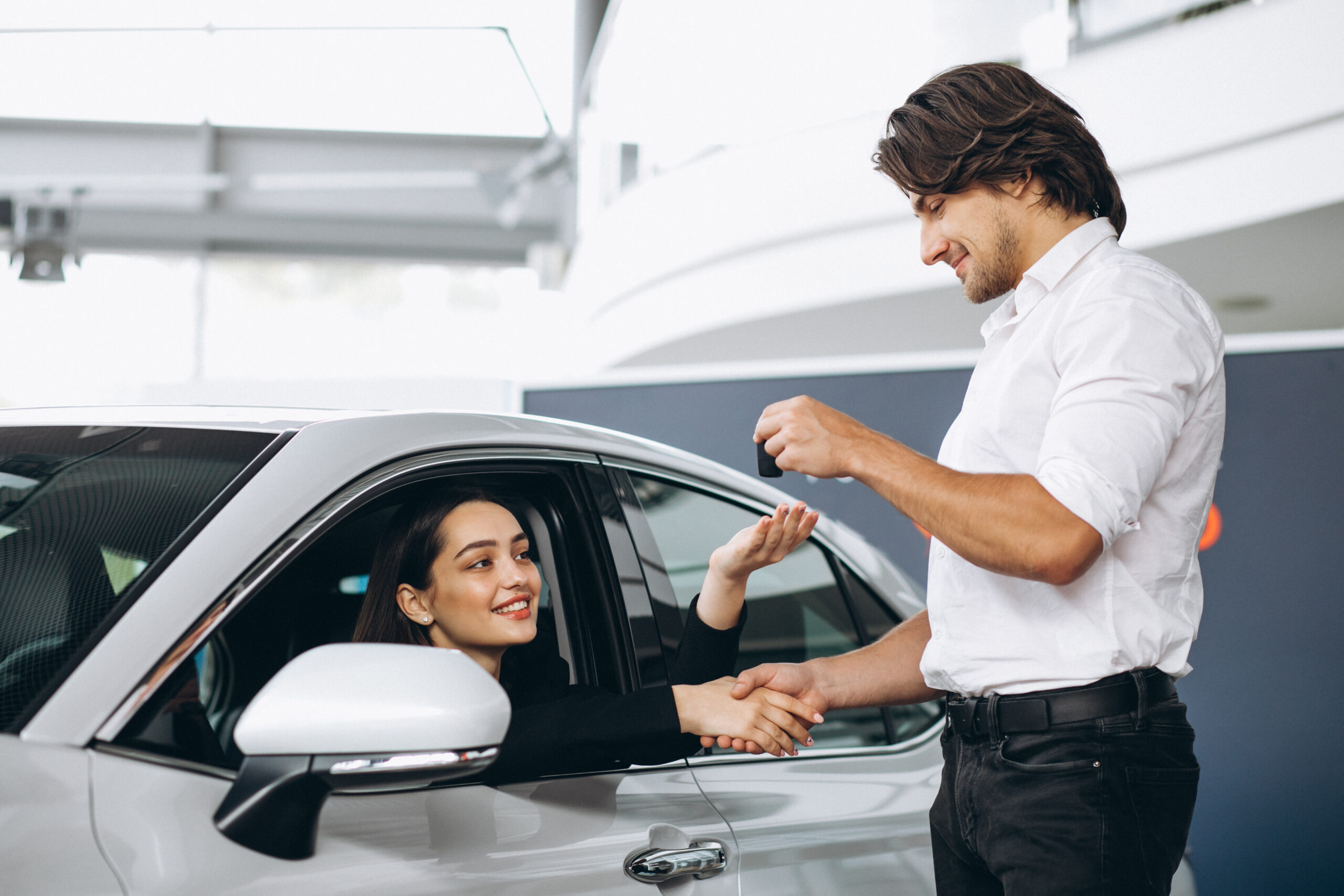 woman talking with male seles person in a car showroom